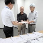 市職員に住民投票条例の制定請求書を手渡す「まもる会」のメンバーら＝三田市役所