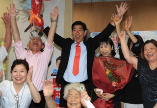 支援者らと喜びを爆発させる田村克也氏（中央）と泉房穂氏（左奥）ら＝三田市下井沢（撮影・吉田敦史）