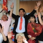 支援者らと喜びを爆発させる田村克也氏（中央）と泉房穂氏（左奥）ら＝三田市下井沢（撮影・吉田敦史）