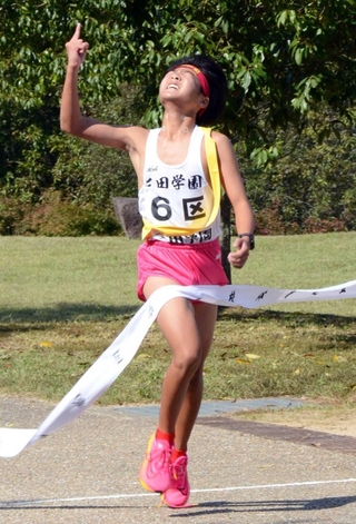 人さし指を突き上げ、ゴールテープを切る男子・三田学園の川嶋帆航選手＝県立丹波並木道中央公園