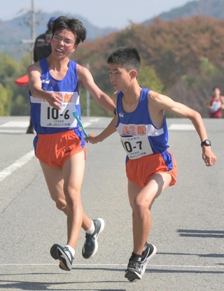 男子・三田祥雲館の６区小林大河選手（左）からたすきを受け取る７区河南知希選手＝丹波篠山市内（撮影・風斗雅博）