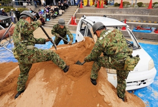 土砂に埋まった車両からの救出。陸上自衛隊員がスコップで土を掘り起こした＝志手原小学校