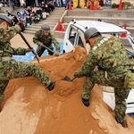 土砂に埋まった車両からの救出。陸上自衛隊員がスコップで土を掘り起こした＝志手原小学校