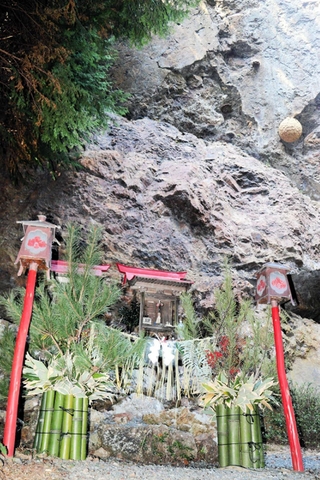 巨岩のふもとのほこらに設置された門松＝三田市母子、天狗岩稲荷神社