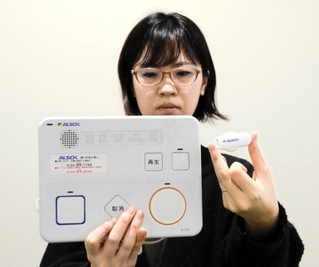 見守りサービスで認知症の高齢者らが身に付けるビーコンタグ（右）と固定機器＝三田市役所