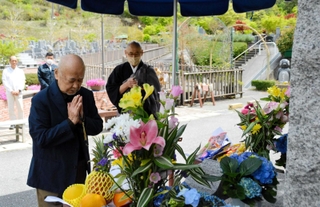 脱線事故の犠牲者を悼み、手を合わせる日笠忠一さん＝神戸市北区道場町生野