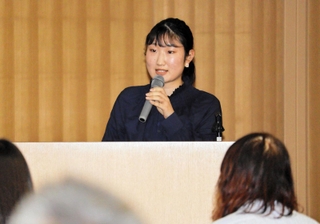 三輪小学校区まちづくり協議会が開いた料理教室の感想や今後の課題などを発表する八田真衣さん＝三田市駅前町