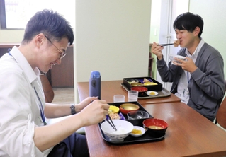 プレオープンに訪れ、同僚と定食を味わう市役所職員＝三田市三輪２、三田市役所