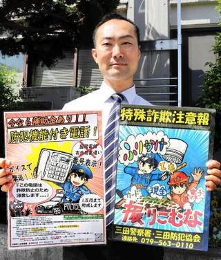 得意のイラストを生かして作成したポスターを紹介する西沢祐樹さん＝三田市天神１、三田署