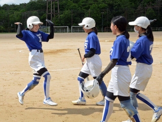 ３点本塁打を放ったゆりのき台の黒瀬彩衣さん（左）を迎える仲間たち＝ゆりのき台中学校