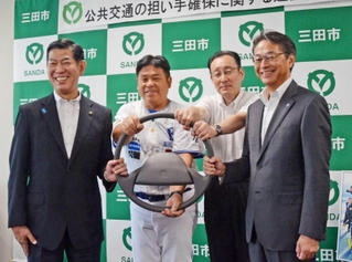 協定を締結した田村克也市長（左端）と神姫バスの長尾真社長（右端）、プロジェクトに参画する「兵庫ブルーサンダーズ」の山崎章弘監督（中央左）と有馬高校の小川秀雄校長＝三田市役所
