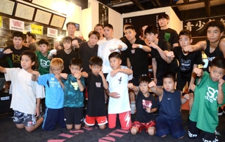 ジムの後輩や子どもたちに送り出される加納陸（後列中央）＝三田市中町、大成ジム