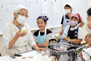 タマネギの収穫時期や切り方を説明する三宅幸子さん（左端）＝フラワータウン市民センター