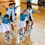 笑顔で一輪車演技を披露する児童たち＝母子小学校