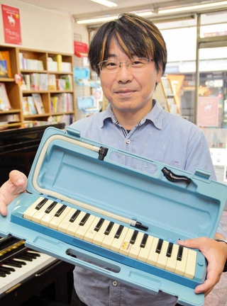 使い込まれた鍵盤ハーモニカを手に、思いを語る平瀬友喜さん＝三田市中央町
