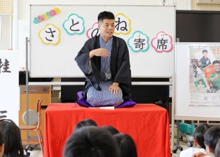 入門１５周年の記念公演を控え、児童らに落語を披露した桂三語さん＝三田市川除、松が丘小学校