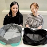 自立するエコバッグ「オリバ」の新モデル（手前左）を開発した山口知夏代表（左）と熊澤恭子執行役員。右の商品は旧型のＬサイズ＝芦屋市川西町