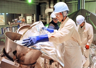 釜の中へ手際よくホップを投入する従業員ら＝神戸市北区赤松台２、キリンビール神戸工場