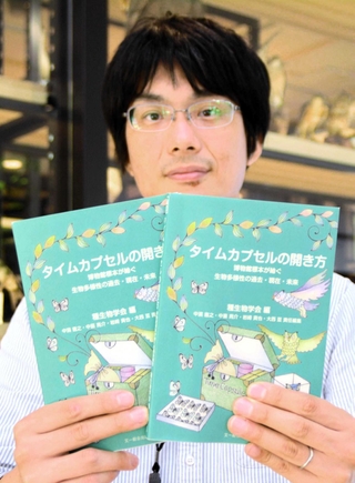 出版した書籍「タイムカプセルの開き方」を手にする中浜直之主任研究員＝三田市弥生が丘６、県立人と自然の博物館