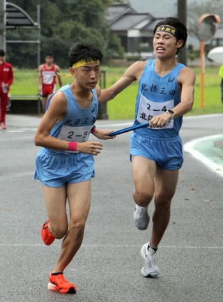 区間新の走りで５区原野雄輝選手（左）にたすきを託す男子・北摂三田の４区畑中登仁選手＝丹波篠山市寺内（撮影・那谷享平）