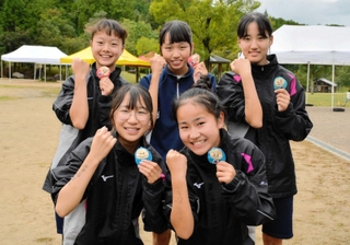 優勝を果たして笑顔を見せる女子・狭間の選手たち。右腕に「絶対優勝」と記して臨んだ＝県立丹波並木道中央公園