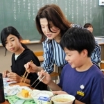 給食の時間、生徒の箸の持ち方を確認して回る樽口知加さん（中央）＝三田市けやき台２、けやき台中学校