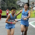 区間新の走りで５区原野雄輝選手（左）にたすきを託す男子・北摂三田の４区畑中登仁選手＝丹波篠山市寺内（撮影・那谷享平）