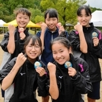 優勝を果たして笑顔を見せる女子・狭間の選手たち。右腕に「絶対優勝」と記して臨んだ＝県立丹波並木道中央公園