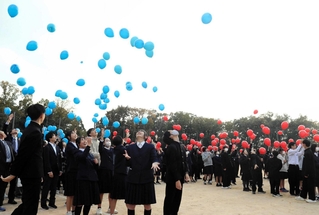 「祝４０ｔｈ」と人文字をつくり、風船を空へ飛ばす生徒ら＝三田市八景町、八景中学校