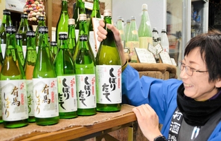 販売が始まった新酒を手に魅力を語る当主の岡村理恵さん＝三田市木器