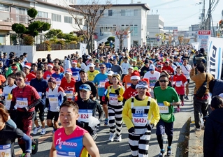 冬の日差しを浴びながらスタートするランナーたち＝三田市天神