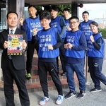 ランニングポリスを務める署員と、背中に掲示するポスターを手がけた西沢祐樹巡査部長（左手前）＝三田市天神１、三田署