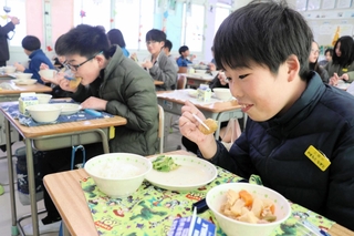 黒大豆枝豆コロッケを美味しそうに頰張る児童＝三田市屋敷町、三田小学校