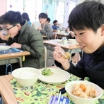 黒大豆枝豆コロッケを美味しそうに頰張る児童＝三田市屋敷町、三田小学校