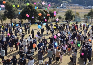 感謝の思いを乗せて風船を飛ばす参加者＝高平幼稚園