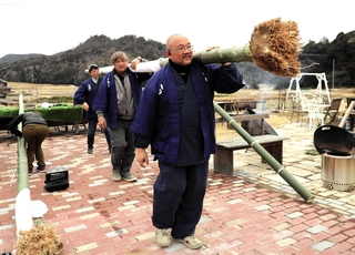 根の付いた竹を運び出す行者や住民＝三田市波豆川