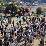 感謝の思いを乗せて風船を飛ばす参加者＝高平幼稚園