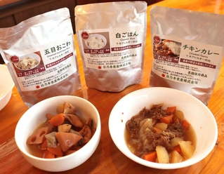 日乃本食産が手がける災害用備蓄食。チキンカレーや五目おこわなどをそろえる＝三田市志手原
