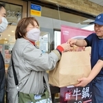 吉野家の「１７６号線三田店」で、用意してもらった牛丼を受け取る女性ら＝三田市三輪４