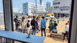 三田市のフラワータウンで開かれる喫茶イベントに合わせ、保護者発案のベーゴマ遊びを楽しむ大人と子どもら