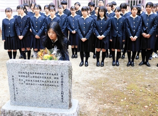 事故で亡くなった石井勝さんを悼み、顕彰碑に献花する山橋未央部長（手前中央）と部員たち＝三田市南が丘２