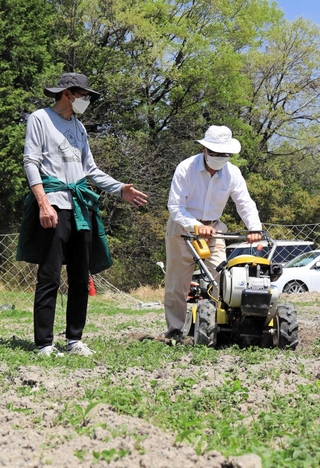スタッフ（左）に見守られながら耕運機を使う参加者＝三田市尼寺