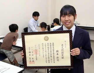 全国珠算学校連盟から贈られた「名人位」の認定証を持つ岡本彩羽さん＝三田市弥生が丘１