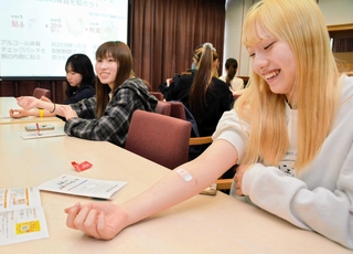 アルコールに対する体質を調べるパッチテストに取り組む学生ら＝神戸市北区赤松台２