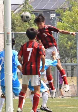 ヘディングでチーム２点目のゴールを決める三田学園の草野圭汰さん（８）＝駒ケ谷運動公園