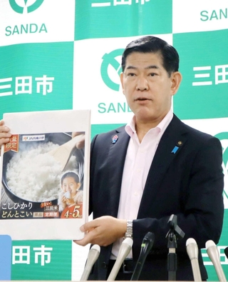 新潟県上越市の中川幹太市長の発言を受け、会見した三田市の田村克也市長。三田米の紹介パネルを手に語った＝三田市役所
