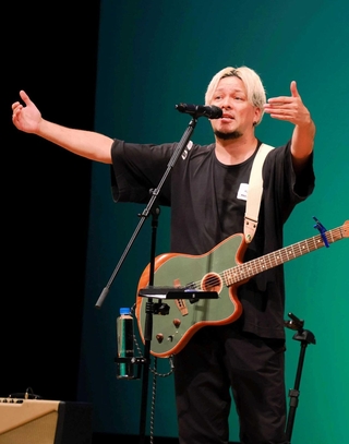 「音楽で国境を越えて伝えたい！」をテーマに、南アフリカの歴史や自身の少年時代を語る染谷西郷さん＝三田市天神１