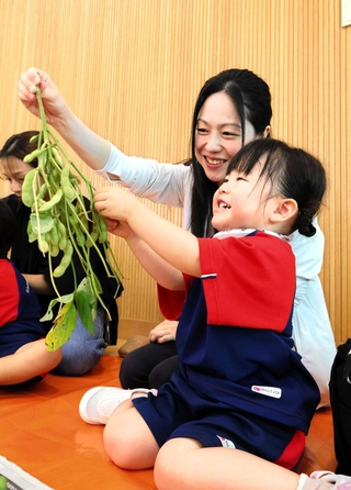 枝豆のさやもぎ体験を楽しむ親子ら＝三田市ゆりのき台５