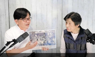 当時の写真を見ながら、学校生活などを振り返る志儀喜代美さん（動画の一場面）