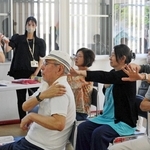 作業療法士の河島くにみさん（左奥）から認知機能を鍛える体操を教わる参加者たち＝三田市弥生が丘１